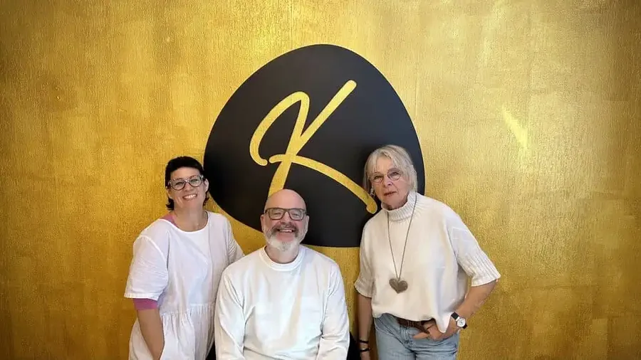 Das Team der Küstenagentur vor dem goldenen K im Büro in Cuxhaven